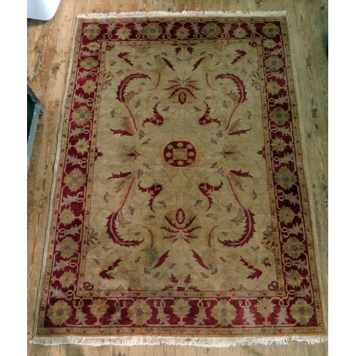 1659 - An Afghan Zeigler rug, the main beige field, with central wine red medallion, within trailing foliag... 