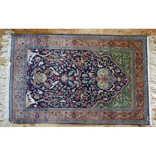 1662 - A Persian silk and wool prayer rug, the indigo mihrab with a garden design of animals and birds amon... 