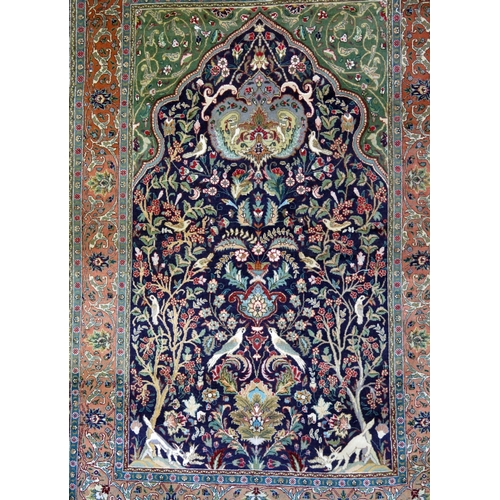 1662 - A Persian silk and wool prayer rug, the indigo mihrab with a garden design of animals and birds amon... 