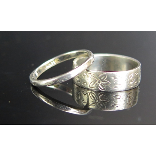 247 - A Platinum Band decorated with chased foliate work (5.5mm wide, size M.5, 7.25g) and a palladium pla... 