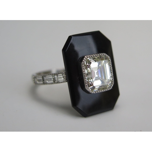 254 - An Emerald Cut Diamond and Onyx Ring in a platinum setting with three baguette cut diamonds to each ... 