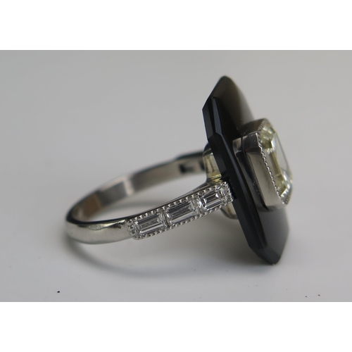 254 - An Emerald Cut Diamond and Onyx Ring in a platinum setting with three baguette cut diamonds to each ... 