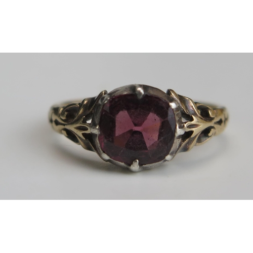 264 - A Garnet or Paste Ring in a precious yellow metal setting, KEE tested as 15ct, size H.25, 2.24g