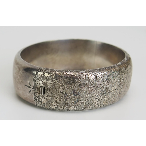 382 - A Victorian Silver Hinged Bangle with chased ivy leaf decoration, Birmingham 1883, H. Bros., 30.45g