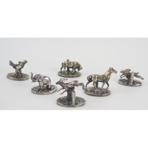 550 - Six white metal novelty  name place holders on oval bases, includes horse, elephant, hare, stag and ... 