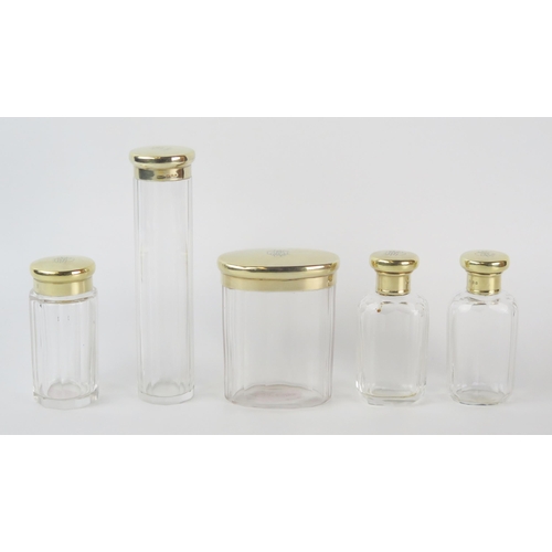 627 - A collection of five Victorian assorted clear glass and silver gilt mounted toiletry bottles and jar... 