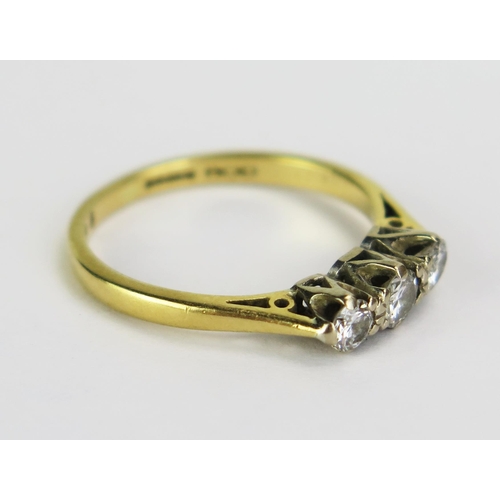 64 - An 18ct Gold and Diamond Three Stone Ring, central stone c. 3.5mm and shouldered by .3mm stones, hal... 