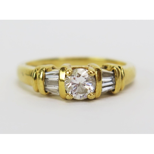 66 - An 18ct Gold and Diamond Ring, the central 5mm stone shouldered by three 2.8mm baguette cut stones, ... 