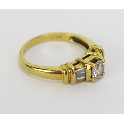 66 - An 18ct Gold and Diamond Ring, the central 5mm stone shouldered by three 2.8mm baguette cut stones, ... 