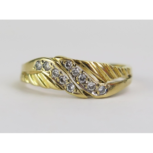 69 - An 18ct Gold and Diamond Dress Ring, set with ten c. c. 1.2mm stones, stamped 18CT, size O, 2.78g