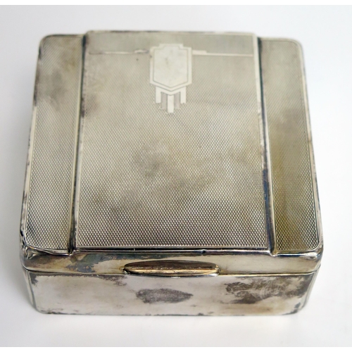 740 - A silver Art Deco period cigarette box, all marks worn, with engine turned decoration, 9cm wide.