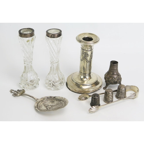 753 - A mixed collection of silverwares, various makers and dates includes candlestick, thimbles, sugar to... 