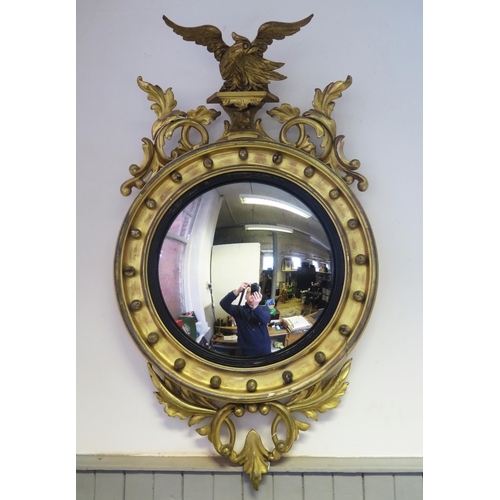 1676 - A Regency style gilt wood wall mirror, the circular convex mirror plate within an ebonised slip encl... 