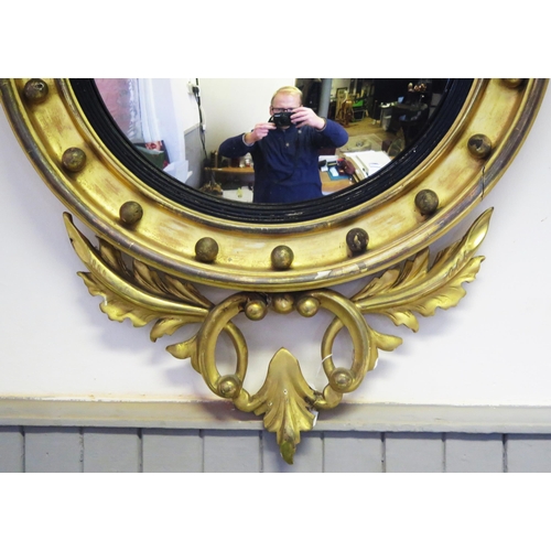 1676 - A Regency style gilt wood wall mirror, the circular convex mirror plate within an ebonised slip encl... 