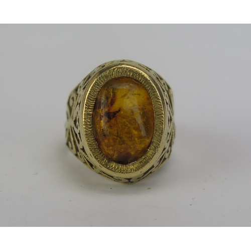 124 - An 18ct Gold and Amber Ring with insect inclusion and pierced foliate shoulders, stamped 18, size I,... 