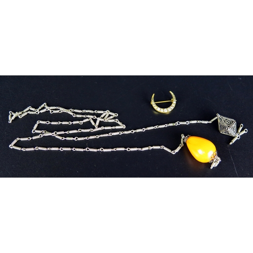 159 - A Black Dot Paste Crescent Brooch and a faux amber bead on white metal chain