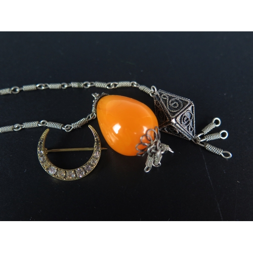 159 - A Black Dot Paste Crescent Brooch and a faux amber bead on white metal chain