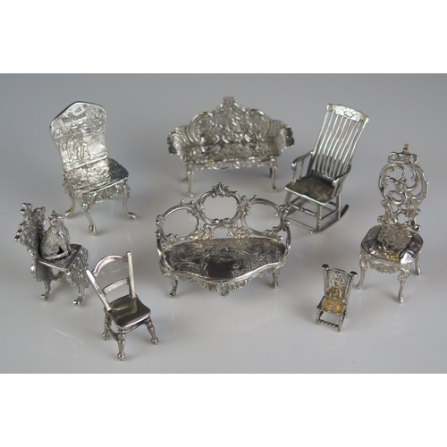 545 - A collection of miniature furniture, various makers and dates includes two sofas and six assorted ch... 