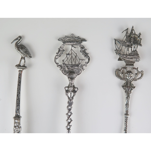 612 - A collection of five assorted silver spoons and slices, all with decorative stems and terminals, tot... 