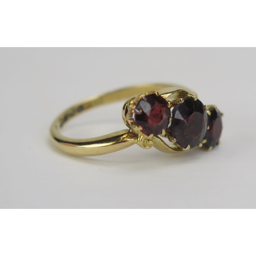 68 - An Antique Garnet Three Stone Crossover Ring, the 6.7mm central stone shouldered by two 5.48mm, the ... 