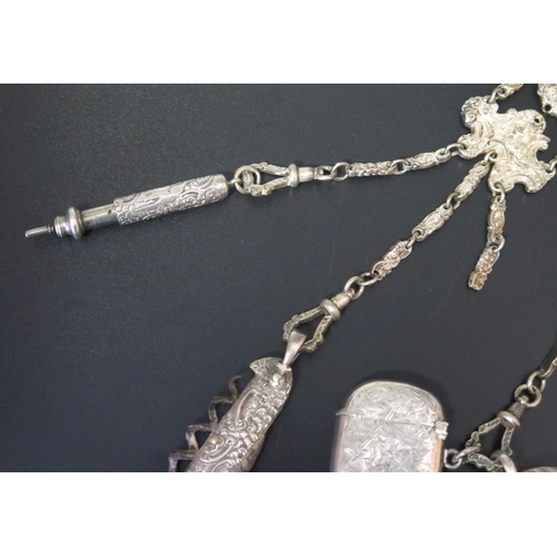 709 - *WITHDRAWN* A silver plated chatelaine with three chain suspensions with pen knife, aide memoire, ve... 