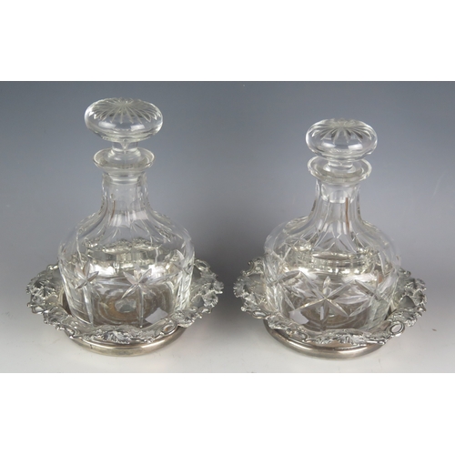 731 - A pair of silver plated coasters, with grape and vine leaf decoration, having tuned circular wood ba... 