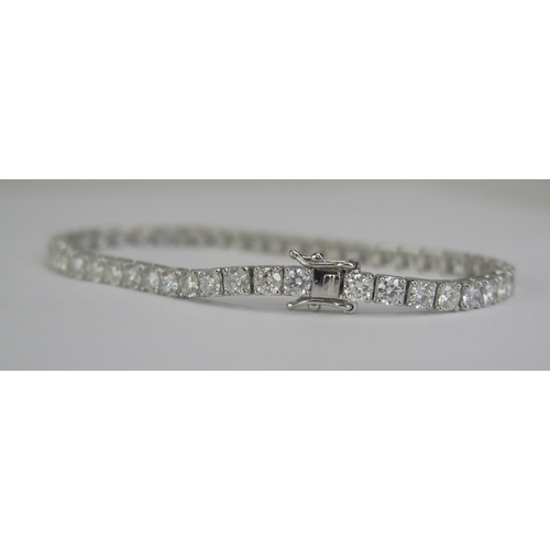 86 - An 18K White Gold and Diamond Tennis Bracelet, stamped 18K, 6.95cts of diamonds, set with 47 c. 3.5m... 