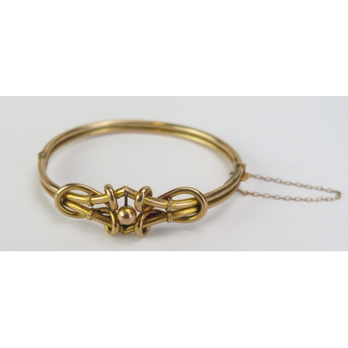 93 - A 9ct Gold 'Knotted' Hinged Bangle with safety chain, stamped 9CT and 375, early 20th century, 8.04g