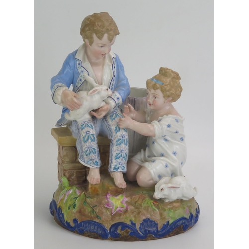 1055 - A Paul Duboy porcelain spill vase decorated with a seated boy and kneeling girl playing with rabbits... 