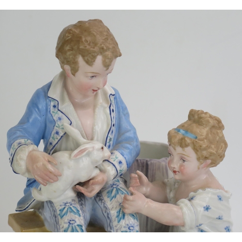 1055 - A Paul Duboy porcelain spill vase decorated with a seated boy and kneeling girl playing with rabbits... 