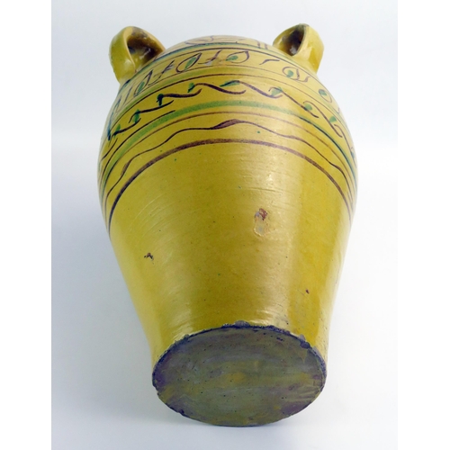 1065 - A large Arabic pottery khablya (storage jar) of ovoid form with four ring handles, and banded polych... 