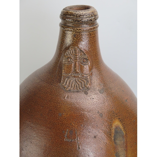 1068 - A large German stoneware Bellarmine jug, 43cm high, together with three  bellarmine jug necks. (4)