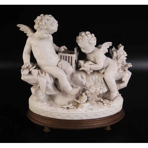 1076 - A continental bisque porcelain figure group of cherubs with birdcage and birds, on a naturalistic ba... 