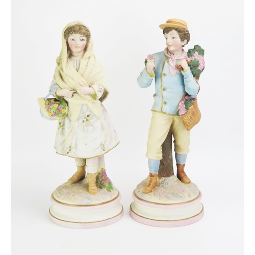 1086 - A large pair of late 19th century German bisque porcelain figures of a boy and girl carrying springt... 