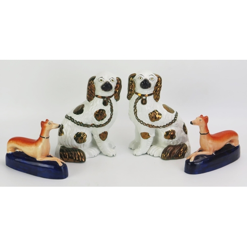 1096 - A pair of Staffordshire pottery King Charles spaniels with gilt decoration and separated front leg, ... 