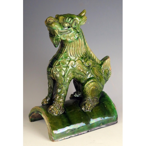 1334 - A Chinese pottery ridge tile surmounted with a recumbent dragon, 26cm high, a/f.