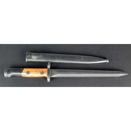 1466 - A Belgian SA30 bayonet with 23cm double edged blackened blade, wood grips, contained in a metal shea... 