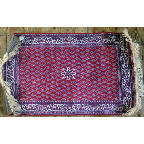 1566 - A Persian design rug, the wine red field with central flowerhead medallion and rows of boteh, enclos... 