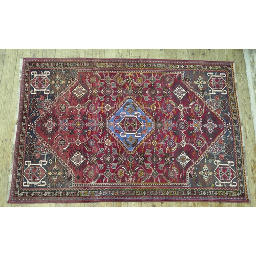 1568 - A Persian design rug, the wine red field with central powder blue stepped lozenge medallion and all ... 