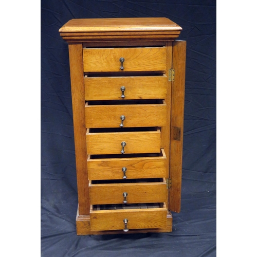 1578 - An oak Wellington style chest, the top with a moulded edge and containing seven short drawers with l... 