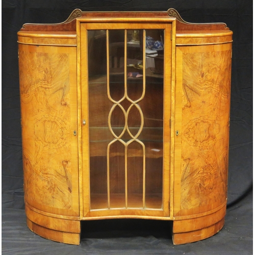 1582 - An Art Deco period walnut display cabinet of inverted serpentine outline, with central glazed door e... 