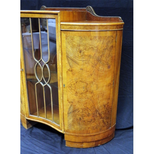 1582 - An Art Deco period walnut display cabinet of inverted serpentine outline, with central glazed door e... 