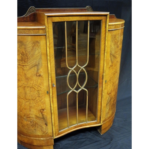 1582 - An Art Deco period walnut display cabinet of inverted serpentine outline, with central glazed door e... 