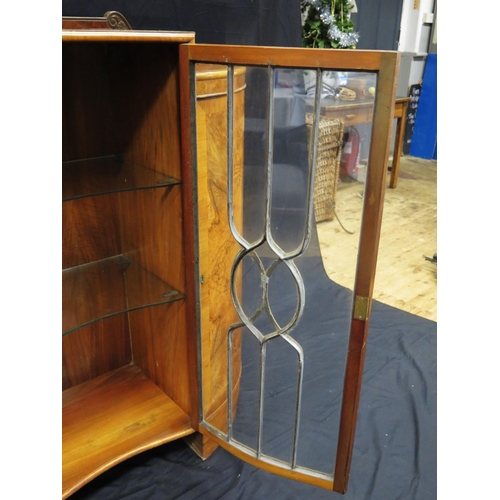 1582 - An Art Deco period walnut display cabinet of inverted serpentine outline, with central glazed door e... 