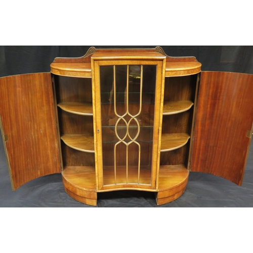 1582 - An Art Deco period walnut display cabinet of inverted serpentine outline, with central glazed door e... 