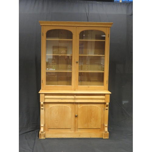 1601 - A Victorian stripped pine kitchen dresser, The upper part with a moulded cornice and a pair of arche... 