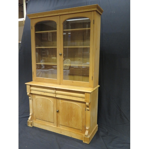 1601 - A Victorian stripped pine kitchen dresser, The upper part with a moulded cornice and a pair of arche... 