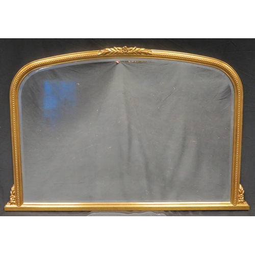 1605 - A gilt framed overmantel mirror, of arched outline with bevelled mirror plate and beaded decorated f... 