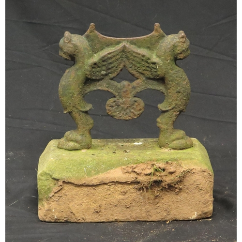 1609 - A cast iron boot scrape, the blade supported by winged griffons, on a stone base.