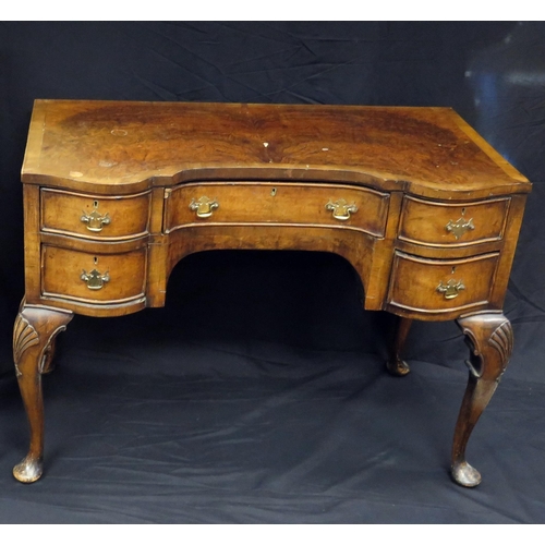 1596 - A reproduction walnut and crossbanded dressing table, of inverted serpentine outline,  the shaped ap... 